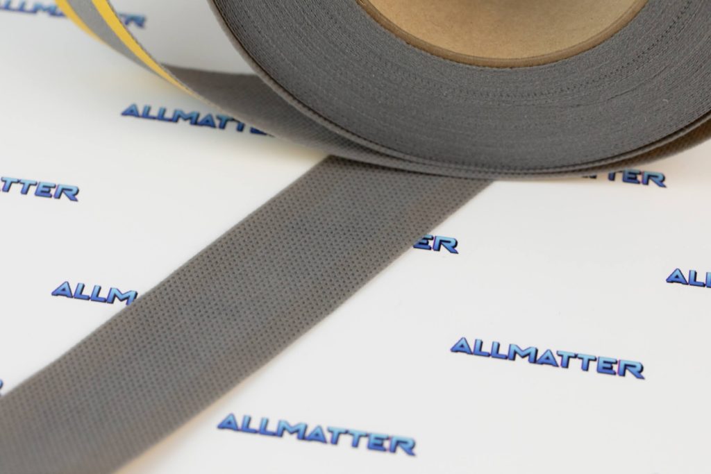 Szara taśma paro przepuszczalna o szerokości 25 mm na tle logotypu