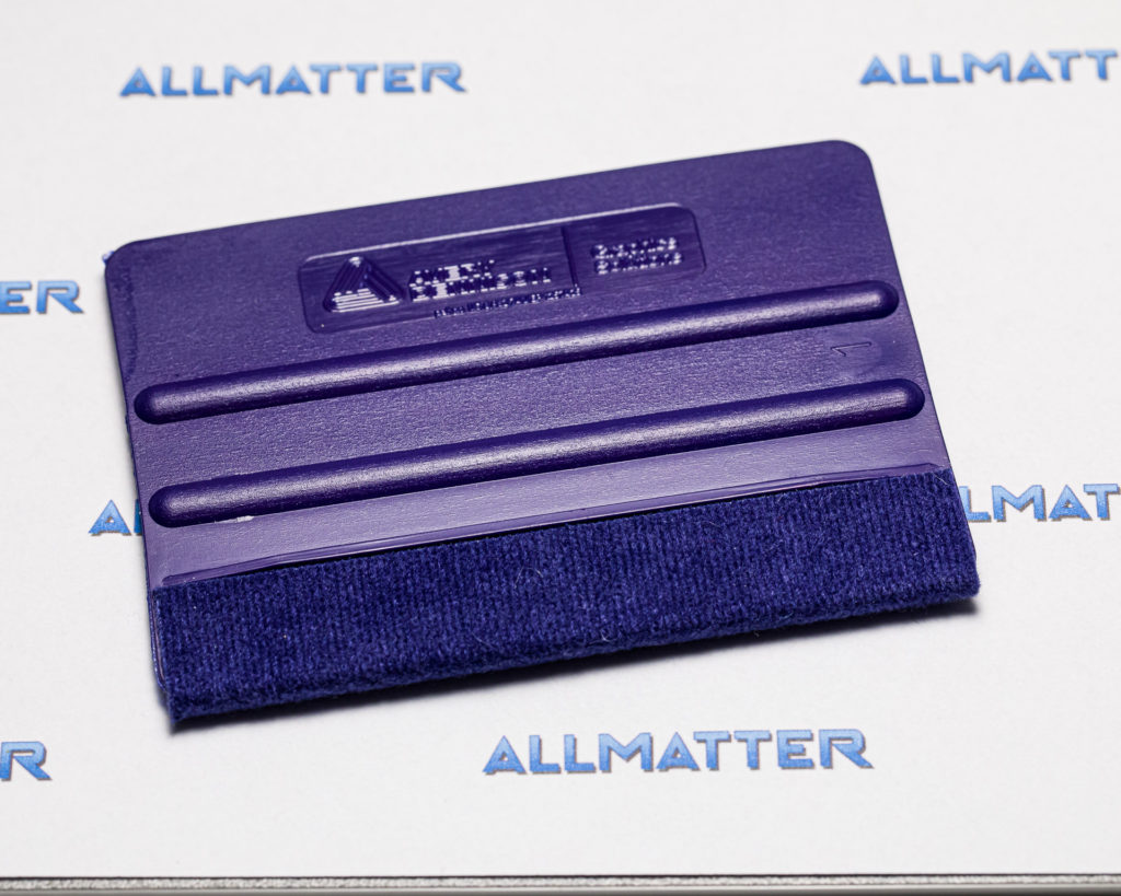 Fioletowa rakla Avery Dennison Squeegee Pro na tle z logo Allmatter