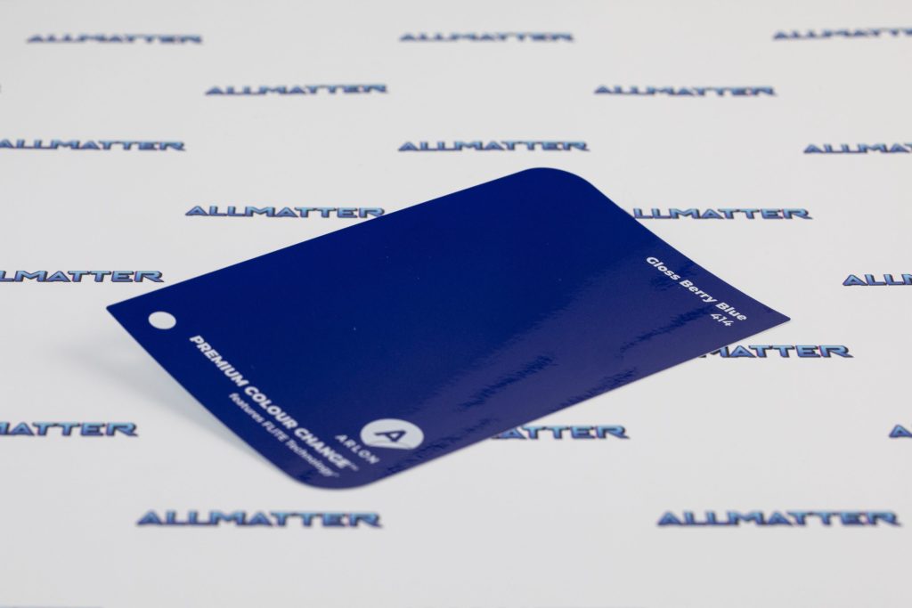 Folia samochodowa w kolorze Gloss Berry Blue 414 na tle logotypu