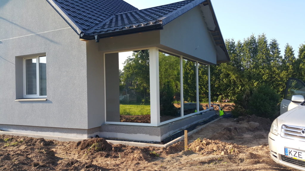 Nowoczesny dom w trakcie budowy z dużymi oknami i ogrodem