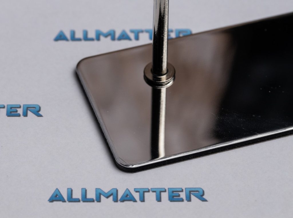 Srebrne lustro na tle z logo Allmatter