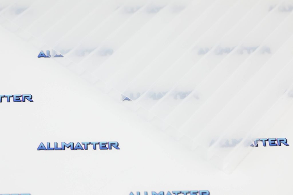 Poliweglan komorowy w kolorze opalowym na tle logo Allmatter