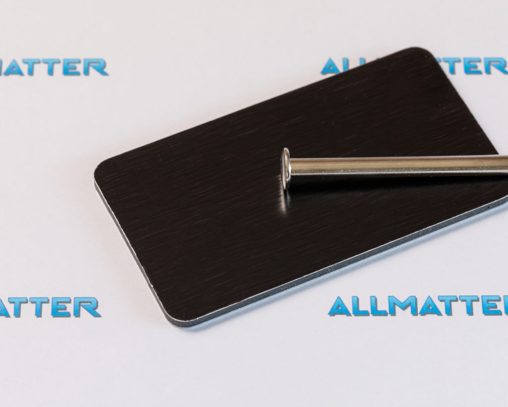 Czarna szczotkowana płyta z metalowym prętem na białym tle