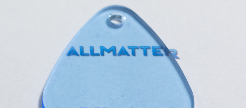 Niebieska zawieszka z napisem ALLMATTER na białym tle