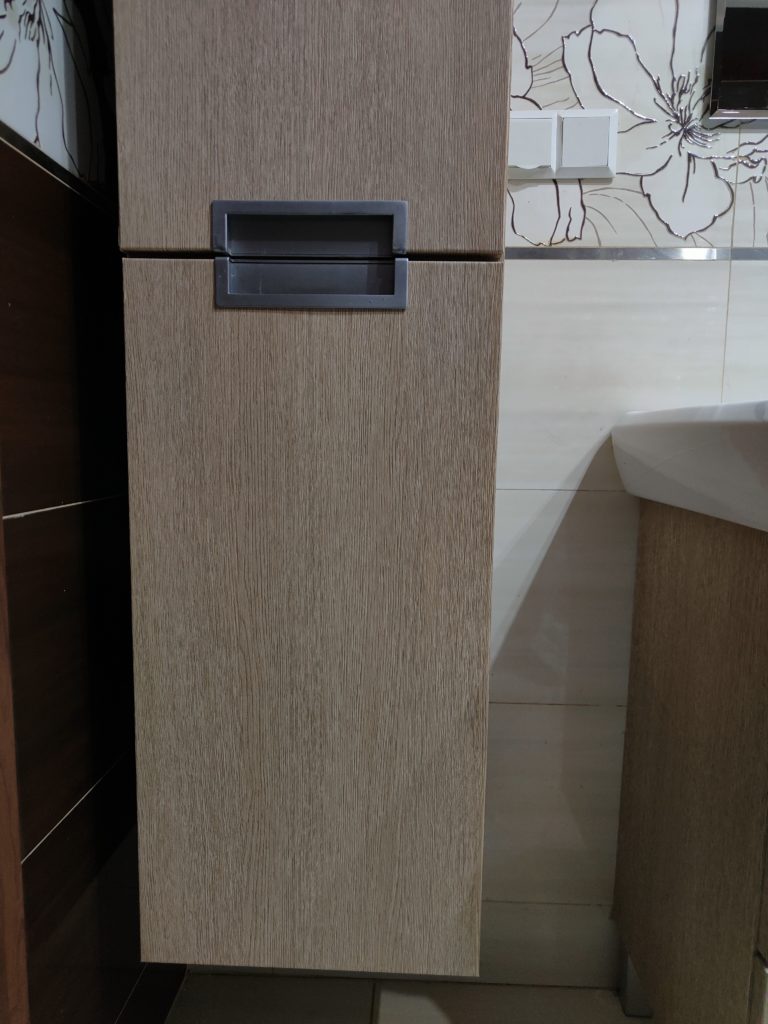 Szafka w kolorze dębu z metalowym uchwytem w łazience