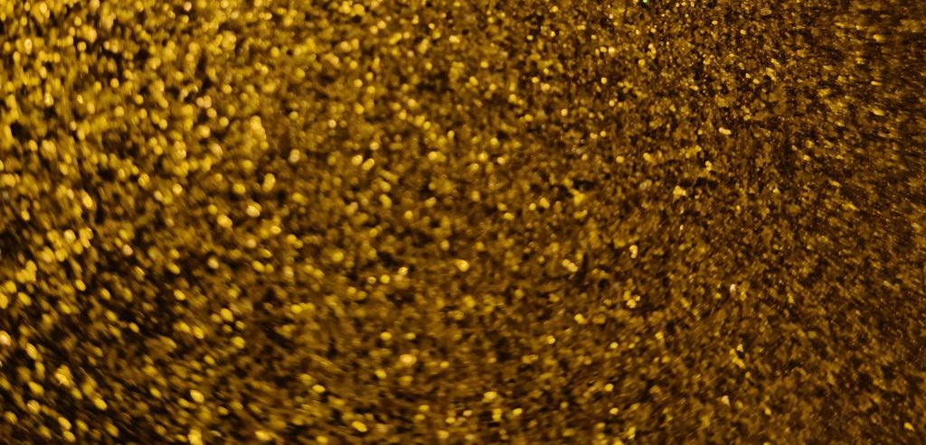 Złota folia architektoniczna z drobinkami w blasku światła